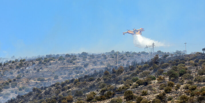 Athens, Greece, June 4, 2022: A firefighting Canadair CL-215 aircraft operates in Hymettus mount wildfire near Glyfada suburb of Athens.