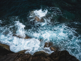 Scenic high angle view of powerful wave crashing on rocky coastline with white splash foam on deep blue water. Moondance Magic Viewpoint, Koh Tao Island, Surat Thani, Thailand. Aerial landscape photo.