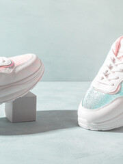 White pastel sneakers with sequins on geometric podiums on turquoise - 508957085
