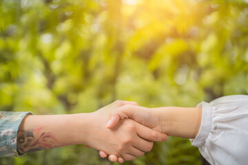 Businessmen handshaking after good deal. Concept of successful business partnership meeting . Holding hands. Close Up view on green nature background. Minimal composition, copy space.