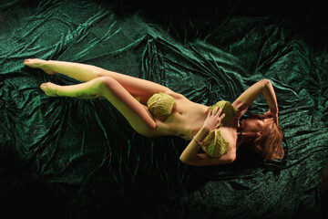 Nackte Frau liegt auf grünem Samt und bedeckt sich mit Wirsing - obrazy, fototapety, plakaty