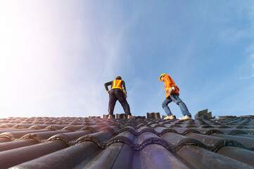 A team of construction workers in work clothes installed new roofing equipment. roofing tools,...