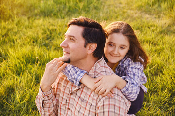 Fototapeta premium Smiling little girl hugging her father outside