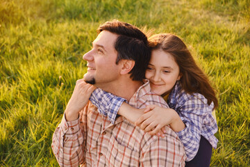 Fototapeta premium Smiling little girl hugging her father outside