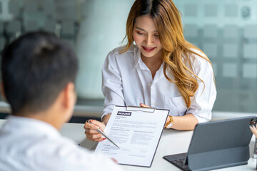 Obraz premium Business, career and recruitment concept - young asian woman smiling and holding resume, while interviewing as candidate for job in big company