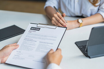 Business, career and recruitment concept - young asian woman smiling and holding resume, while interviewing as candidate for job in big company