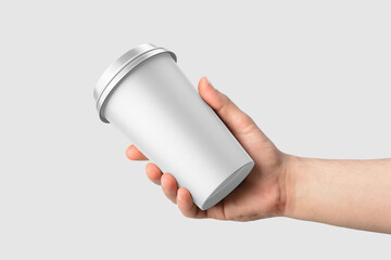 Paper coffee cup with plastic cap in a hand mockup template, isolated on light grey background. High resolution.