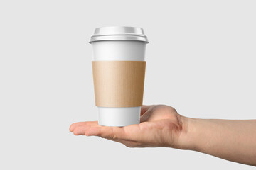 Paper coffee cup with sleeve in a hand mockup template, isolated on light grey background. High resolution.