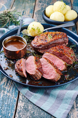 Traditional barbecue gourmet duck breast filet with skin served with dark beer sauce as close-up on...