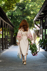 Ukrainian girl in vyshyvanka with a bouquet of peonies