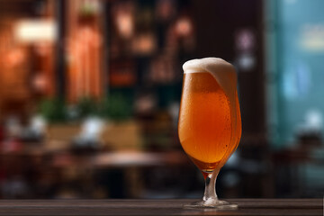 Tulip glass of beer on counter in pub.
