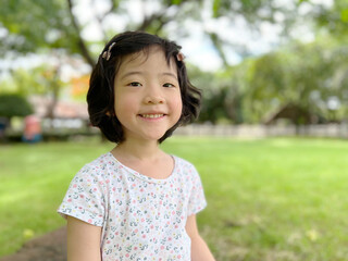 cute little girl smiles in the garden with copy space