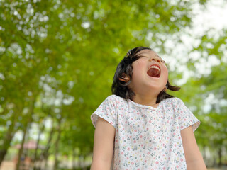 Cute little girl is laughing in the garden