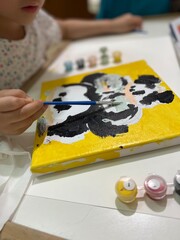 cute little girl paints on her painting