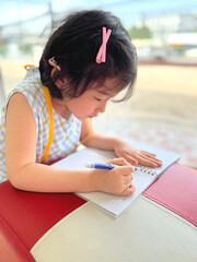 cute little girl writes on her notebook