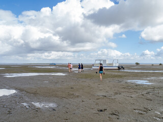 People walking towards the water at low tide