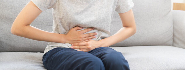 Flatulence asian young woman, girl hand in stomach ache, suffer from food poisoning, abdominal pain...