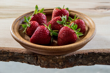 Fresh strawberries in a wooden bowl.