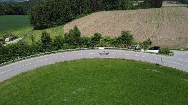 Oldtimer auf Serpentinen in gr&uuml;ner l&auml;ndlichen Gegend aus der Luft