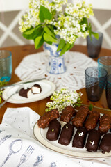 Homemade cottage cheese curds or cheese cakes with dark and milk choclate glaze and nuts on laid table
