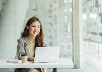 Fototapeta na wymiar Young beautiful woman using her laptop while sitting in a chair at her working place, Small business owner people employee freelance online sme marketing e-commerce telemarketing concept.