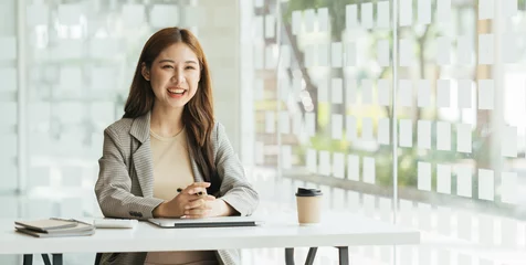 Fotobehang Young beautiful woman using her laptop while sitting in a chair at her working place,  Small business owner people employee freelance online sme marketing e-commerce telemarketing concept. © PaeGAG