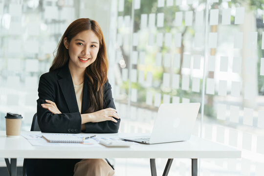Young beautiful woman using her laptop while sitting in a chair at her working place,  Small business owner people employee freelance online sme marketing e-commerce telemarketing concept.