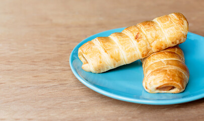 sausage danish in blue plate on wooden background