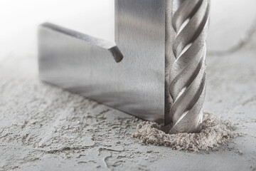 drill bit make holes in concrete wall with steel triangle. Building work industry.
