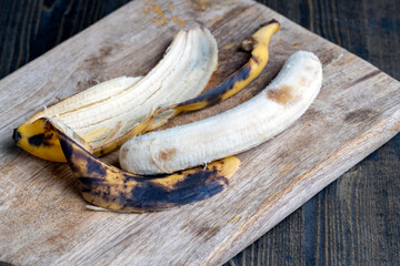 old blackening banana on a cutting board, perishable banana fruit food