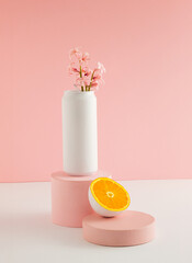 White colored can with spring flower hyacinth and cut in half orange fruit on product podium....