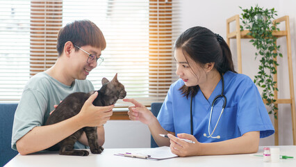 Pet care concept, Female veterinary examining the cat and writing prescription on clipboard