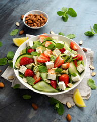 Summer Strawberry, cucumber salad with lettuce, feta cheese and almonds. Healthy Food.