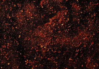 Spicy chili pepper flakes, crushed, milled dry paprika pile isolated on black, top view