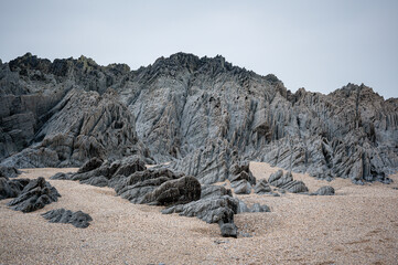 Fototapeta na wymiar Slate, quartz and sandstone rock formations at Barricane Beach, Woolacombe, Devon