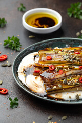 Sweet and sour braised leeks over whipped feta cheese, vegetarian vegan summer Asian style food concept