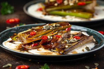 Sweet and sour braised leeks over whipped feta cheese, vegetarian vegan summer Asian style food concept