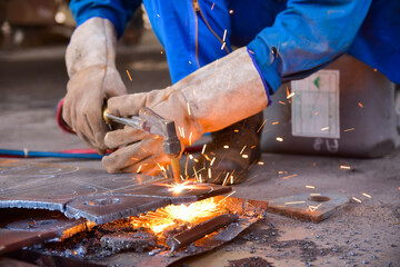 Worker cutting metal steel by Gas Cutting Torch. He cutting the iron plate in the workshop.