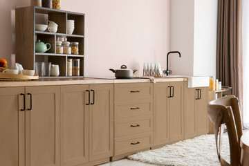 Interior of light modern kitchen with brown furniture