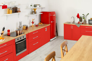 Interior of light kitchen with red fridge and furniture