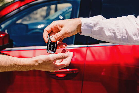 Salesperson giving car keys to the new owner.