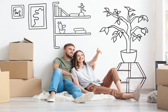 Young couple with moving boxes planning design of their new house