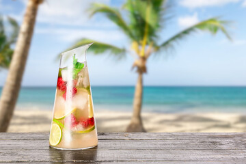 Jug of fresh mojito on table at tropical resort
