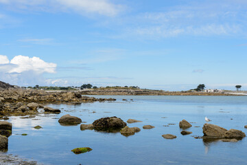 Blue sky and calm sea, Breton shore at low tide. View of a portion of shoreline in Brittany at a place called Saint Michèl France June 2022.