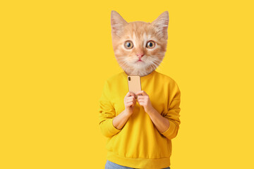 Cute cat with human body holding smartphone on yellow background