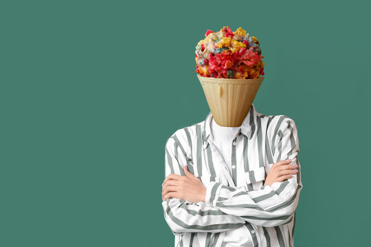Woman with tasty popcorn ball in waffle cone instead of her head on green background