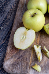 sliced and peeled green apple on a wooden board