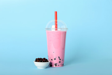 Plastic cup of tasty bubble tea on blue background