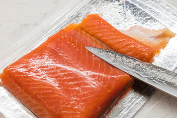 Sliced salmon fillet. Fish in a vacuum blister pack. Close-up