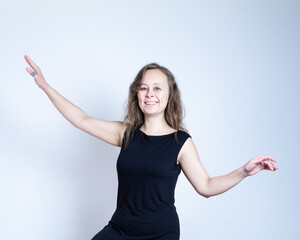 girl in a black dress and with natural make-up keeps balance and smiling